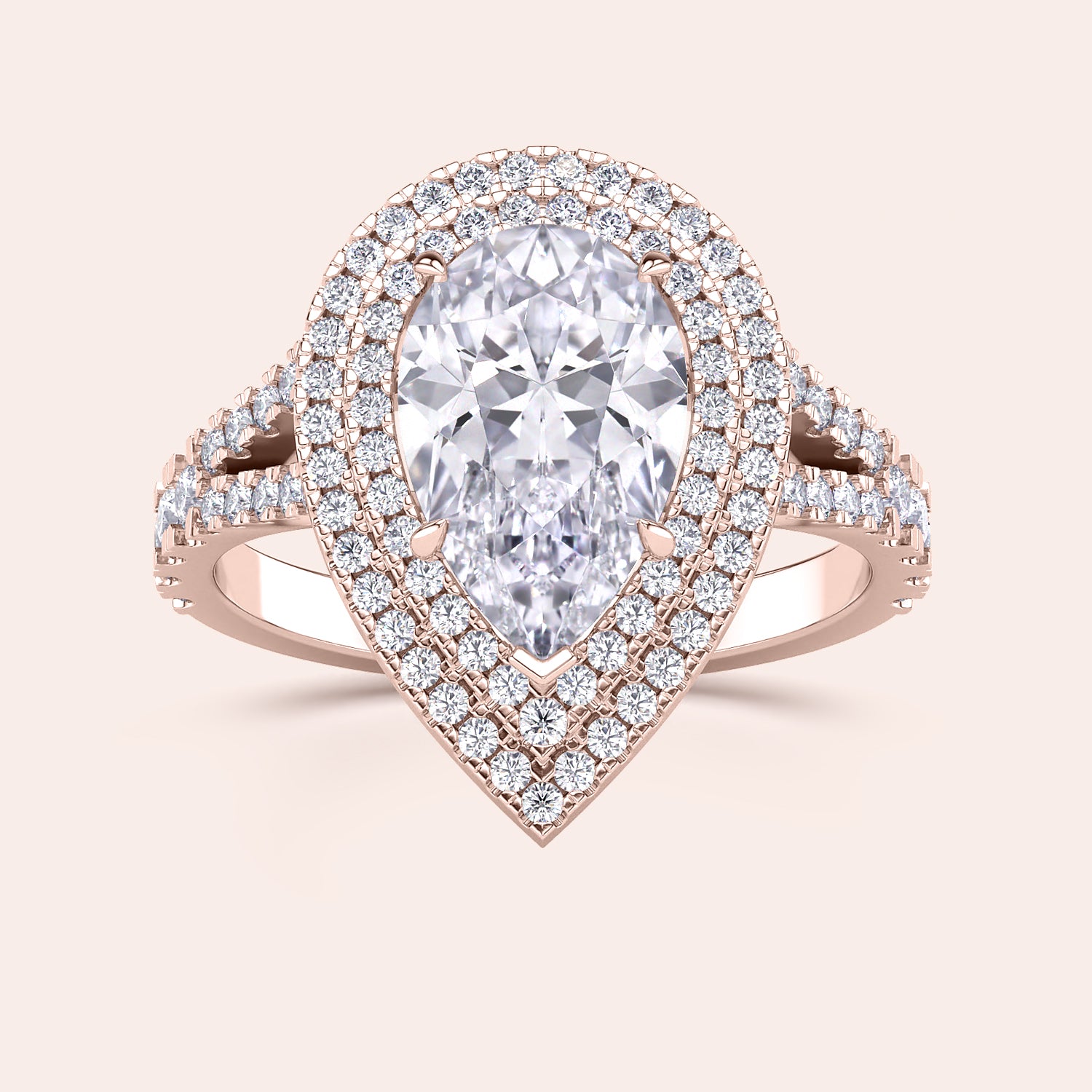 Luxurious rose gold ring with a pear-shaped diamond set in a halo design, accented with a pavé diamond band that splits at the base. #14KRecycledRoseGold #18KRecycledRoseGold