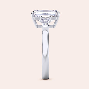White gold engagement ring featuring an elongated emerald-cut diamond, set in a sleek, modern band, with ILANIS engraved inside. 