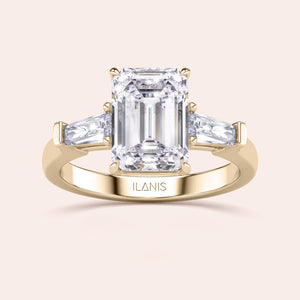 Sophisticated yellow gold engagement ring displaying a large emerald-cut center diamond with trapezoid side stones, enhancing its elegant design. 