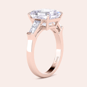 Elegant rose gold engagement ring featuring a radiant cut center diamond with two side baguettes on a smooth band 