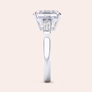 Stunning white gold ring with a central emerald-cut diamond flanked by trapezoid diamonds set in a classic design 