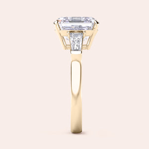 Sophisticated yellow gold ring featuring a unique emerald-cut diamond with distinctive side stones on a polished band 