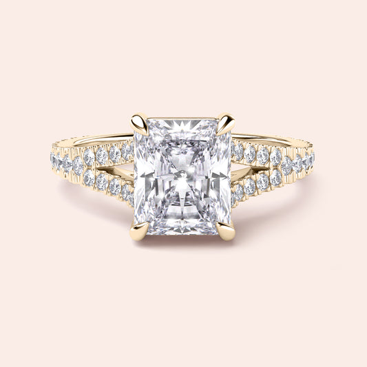 Radiant cut diamond engagement ring in 14K yellow gold with split-shank design and round diamond accents for a stunning look.