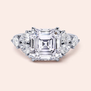 Elegant 14K/18K white gold engagement ring featuring asscher-cut diamond with round side diamonds, showcasing exquisite craftsmanship.