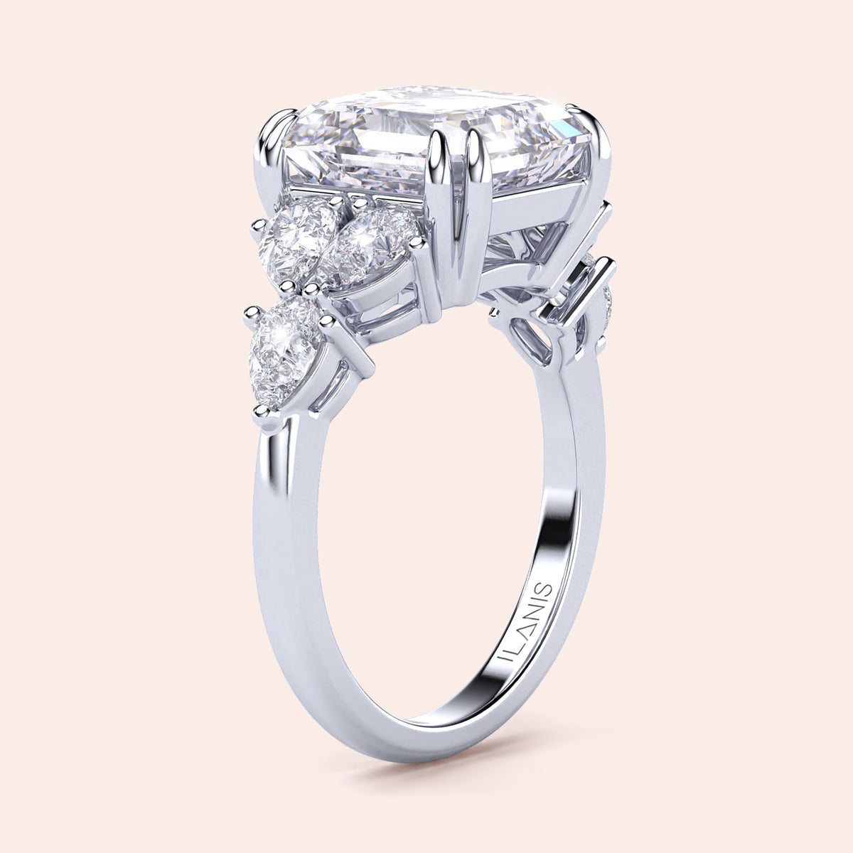 Elegant white gold engagement ring with radiant-cut diamond center and pear-shaped accents, available in 14K, 18K, or platinum.