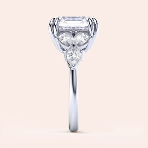 Elegant engagement ring in 14K/18K white gold featuring an elongated radiant-cut diamond, pear-shaped and round diamonds.
