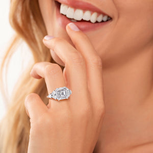 Exquisite 14K white gold ring with Asscher-cut diamond and side stones, elegantly worn on model's finger.
