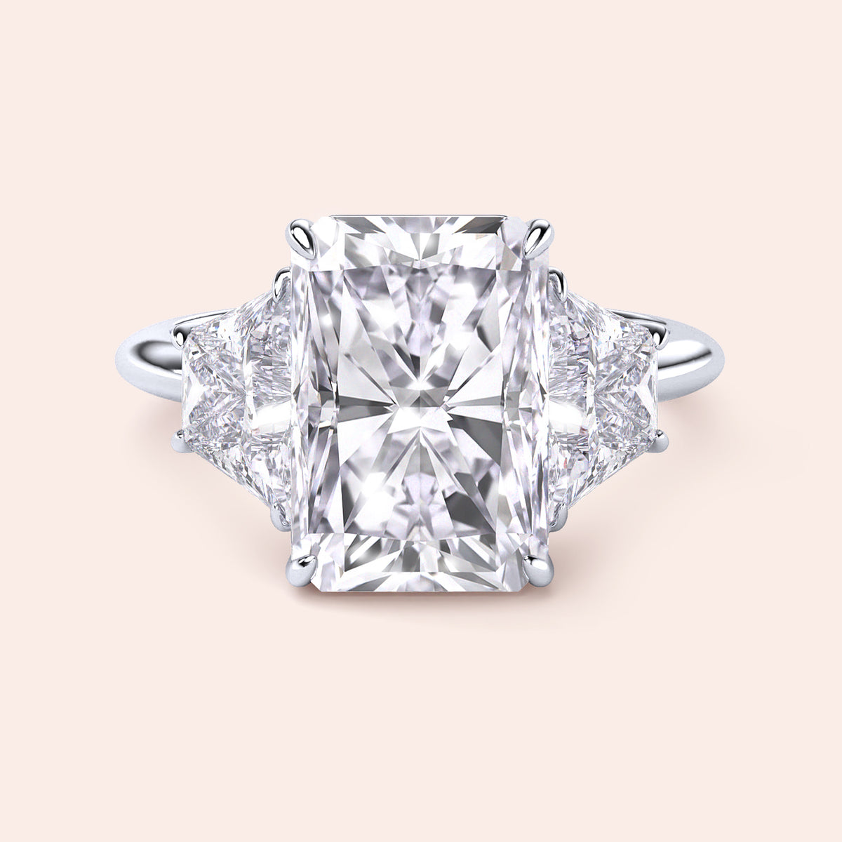 "Radiant cut three-stone engagement ring in 14K/18K gold or platinum, featuring a center diamond and trapezoid side stones."
