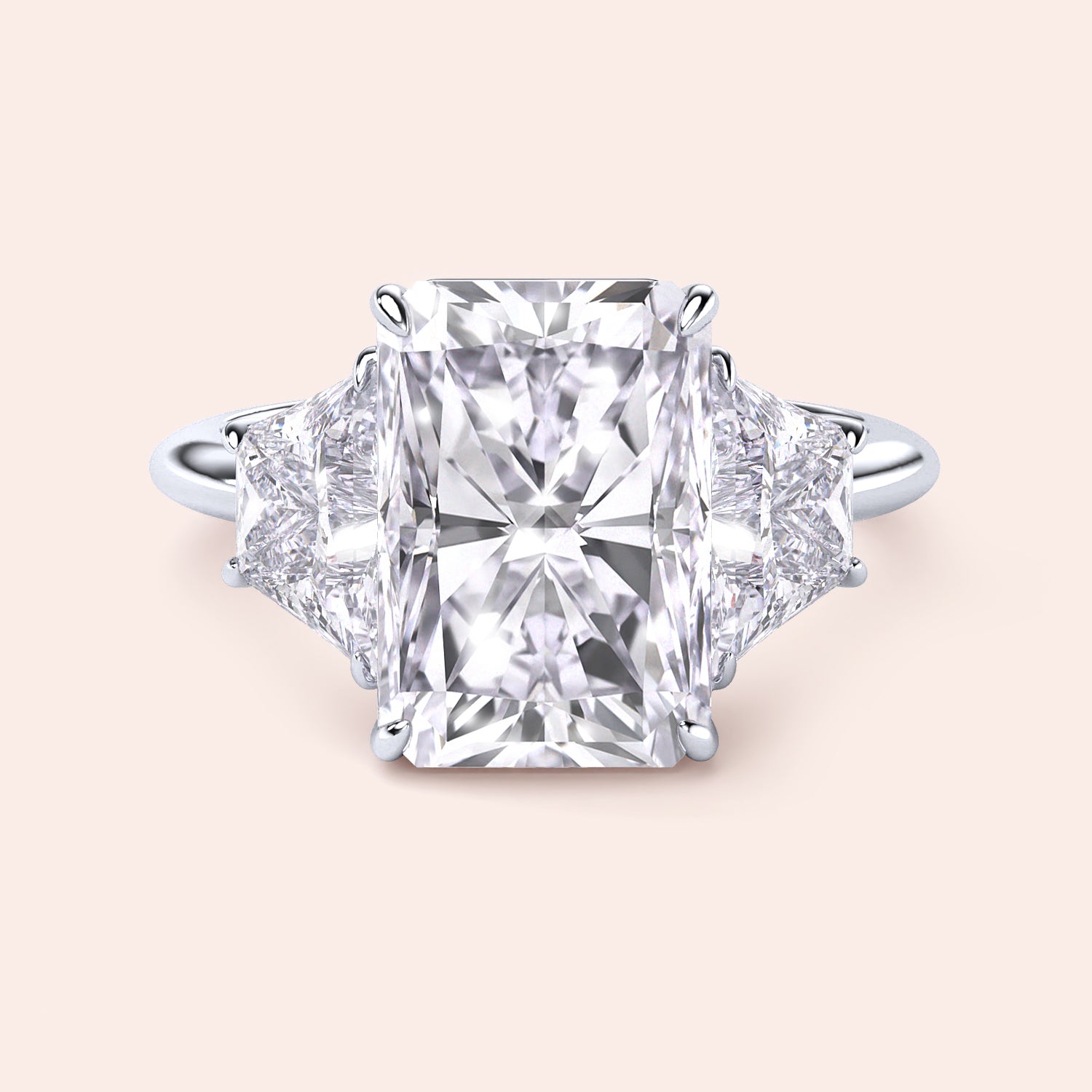 "Radiant cut three-stone engagement ring in 14K/18K gold or platinum, featuring a center diamond and trapezoid side stones."