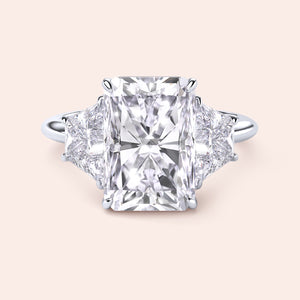 "Radiant cut three-stone engagement ring in 14K/18K gold or platinum, featuring a center diamond and trapezoid side stones."
