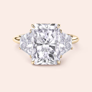 Radiant-cut diamond engagement ring with side stones in 14K gold, showcased against a neutral background.