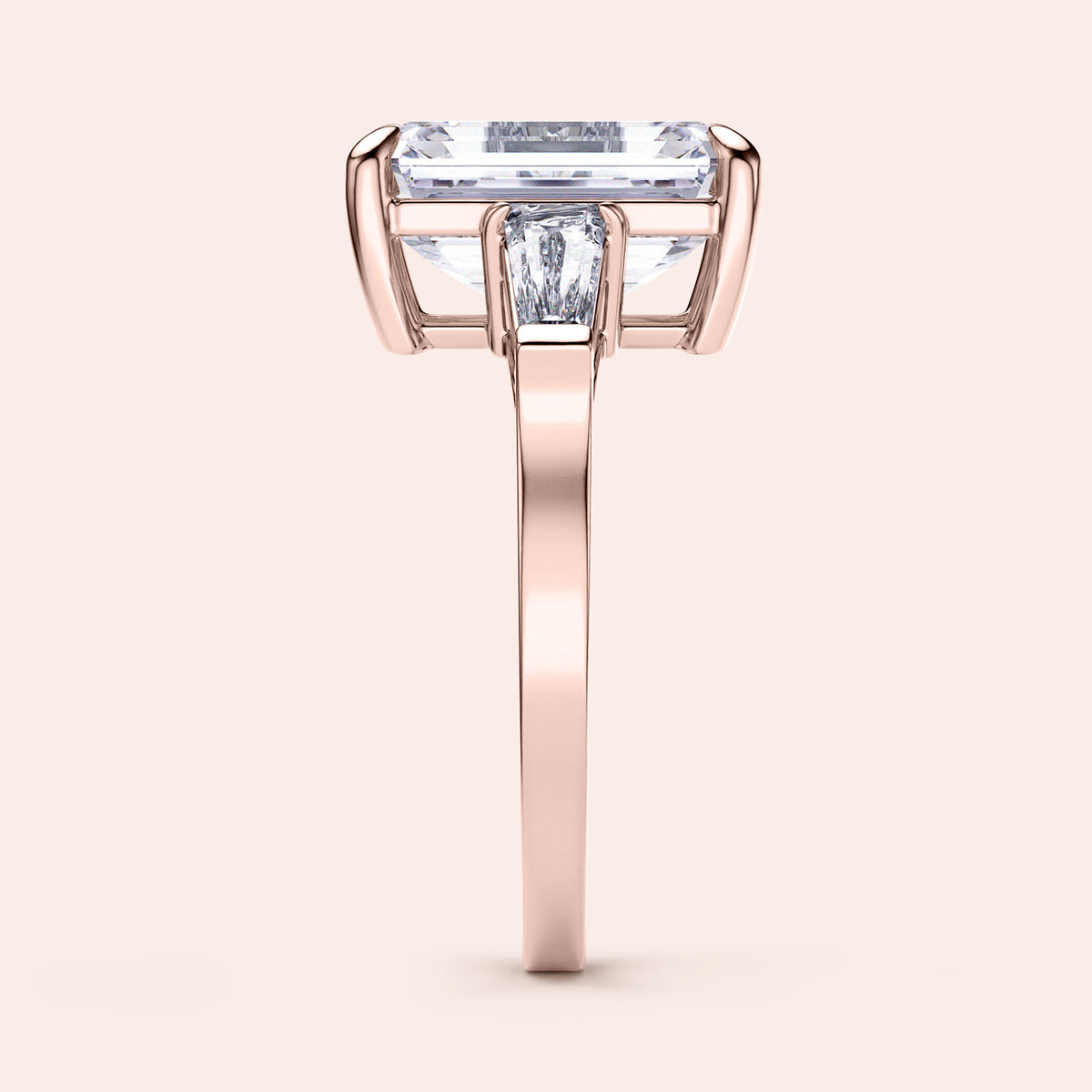 Elegant 14K rose gold engagement ring featuring emerald three stone tapered baguettes for a sophisticated design.