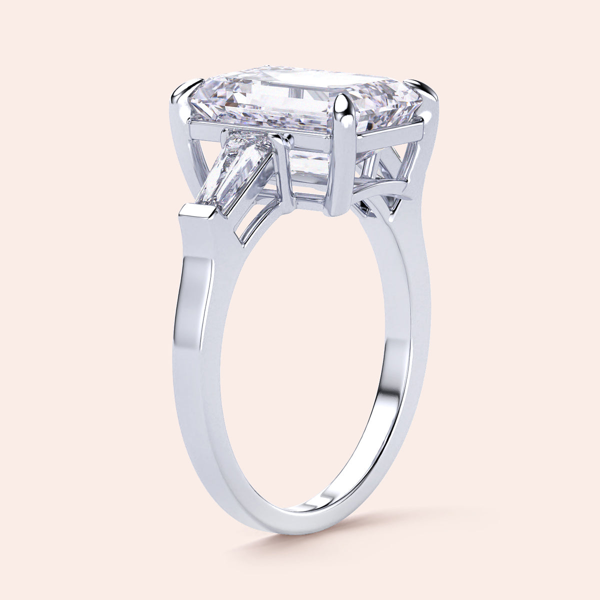 Elegant emerald-cut diamond ring featuring three tapered baguettes, crafted in 14K or 18K white gold or platinum.