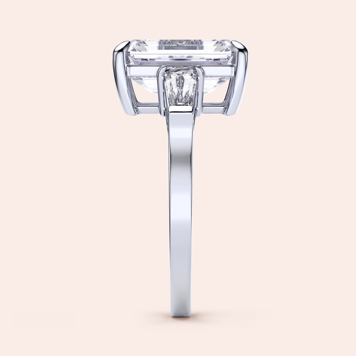 Side view of a radiant-cut emerald engagement ring in 14K white gold, featuring three tapered baguettes and exquisite craftsmanship.
