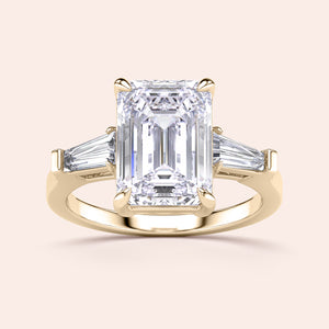 Elegant 14K yellow gold engagement ring featuring an emerald-cut diamond center stone and two tapered baguette diamonds.