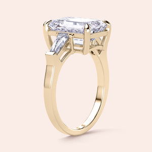 Elegant three-stone emerald-cut diamond ring in 14K/18K yellow gold, featuring tapered baguettes. Note: Jewelry is not worn on a model.