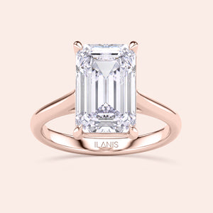 Emerald-cut diamond solitaire engagement ring, set in 14K rose gold, showcased on model for elegant style.