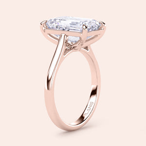 Rose gold engagement ring with an emerald-cut diamond in a prong setting, available in 14K, 18K, and platinum options.