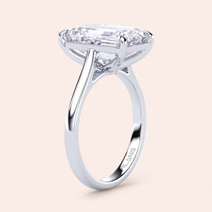 Elegant 14K white gold emerald solitaire engagement ring in cathedral setting, showcasing modern design and brilliant sparkle.