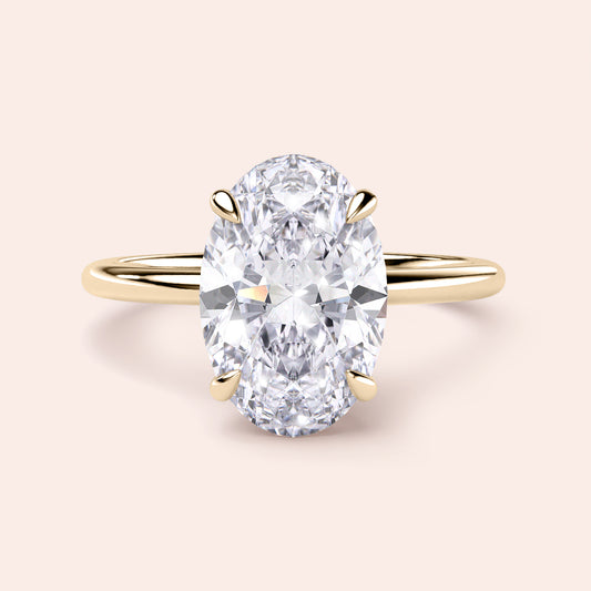 14K/18K gold oval solitaire diamond engagement ring with hidden halo on a minimalistic band, perfect for timeless elegance.