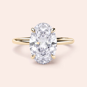 14K/18K gold oval solitaire diamond engagement ring with hidden halo on a minimalistic band, perfect for timeless elegance.