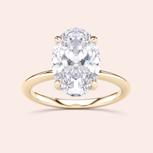 14K or 18K Gold engagement ring featuring an oval diamond solitaire with a hidden halo, elegantly presented against a simple background.