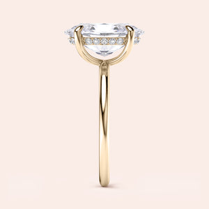 Marquise-cut diamond engagement ring in 14K yellow gold, featuring a delicate pave band on a neutral background.