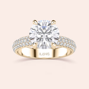Elegant 14K/18K gold engagement ring with a round cut diamond and diamond-encrusted band by ILANIS. Stunning craftsmanship.