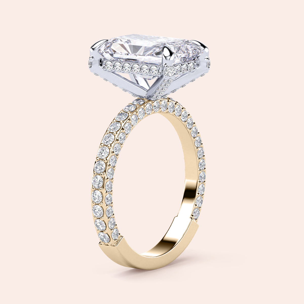 Two-tone 14K gold emerald-cut diamond ring with pav‚ setting, featuring a radiant hidden halo in white and yellow gold. 