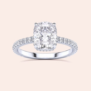 14K/18K/Platinum engagement ring featuring a cushion-cut diamond center stone and diamond-accented band on a neutral background.