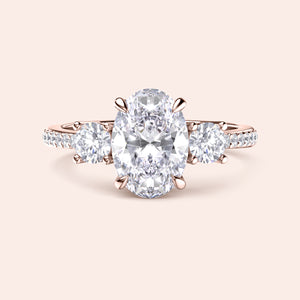 Oval diamond engagement ring in 14K rose gold, featuring a central oval diamond with side round stones and pave accents.