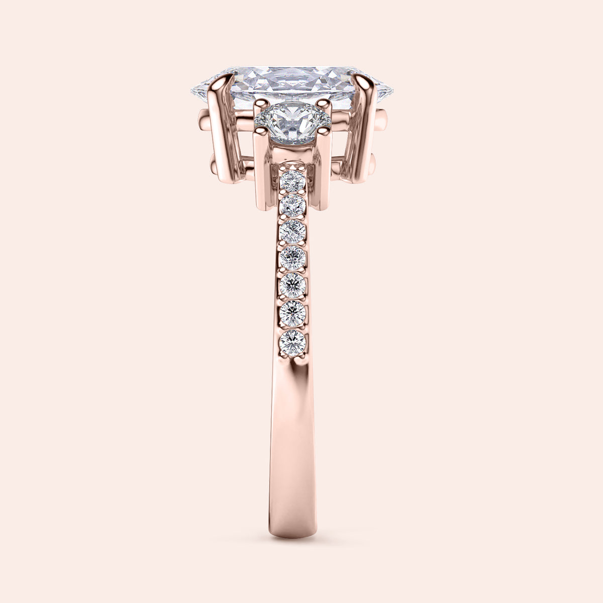 Elegant 14K rose gold engagement ring featuring an oval three-stone design with pave accents. Intricate side view detail.