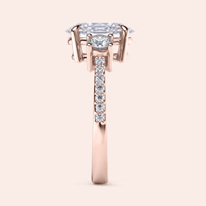 Elegant 14K rose gold engagement ring featuring an oval three-stone design with pave accents. Intricate side view detail.