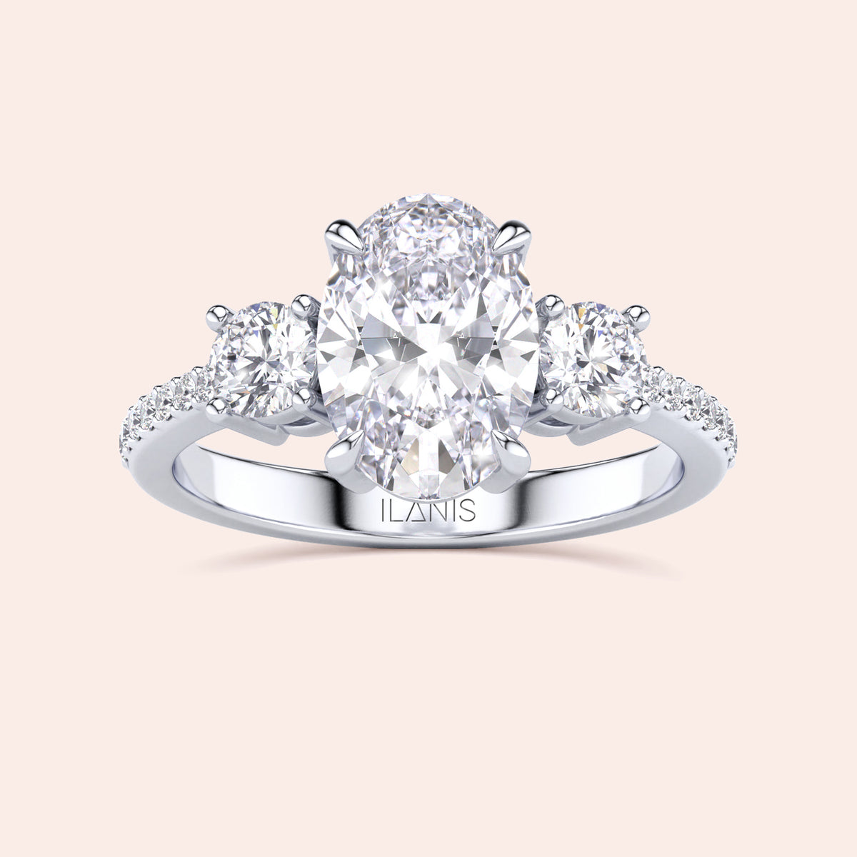 Elegant 14K or 18K gold three-stone engagement ring with oval center diamond and round side stones on aPave band.
