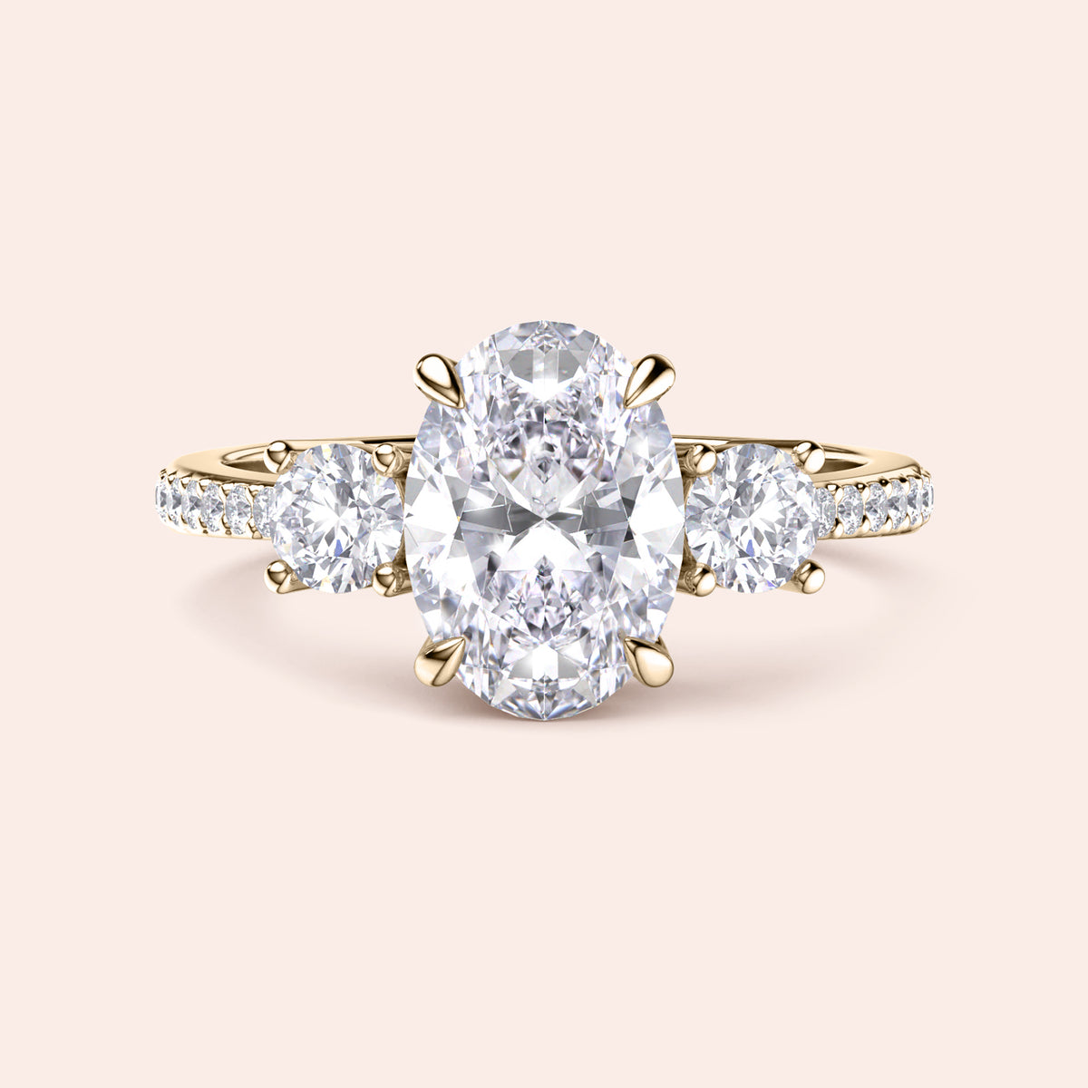Elegant three-stone engagement ring with oval-cut diamond and round-cut stones in 14K yellow gold or platinum, featuring aPave band.