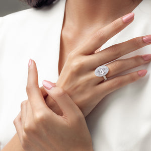 Elegant two-tone 14K gold oval diamond ring with double-edge halo, modeled in white and yellow gold for stunning contrast. 
