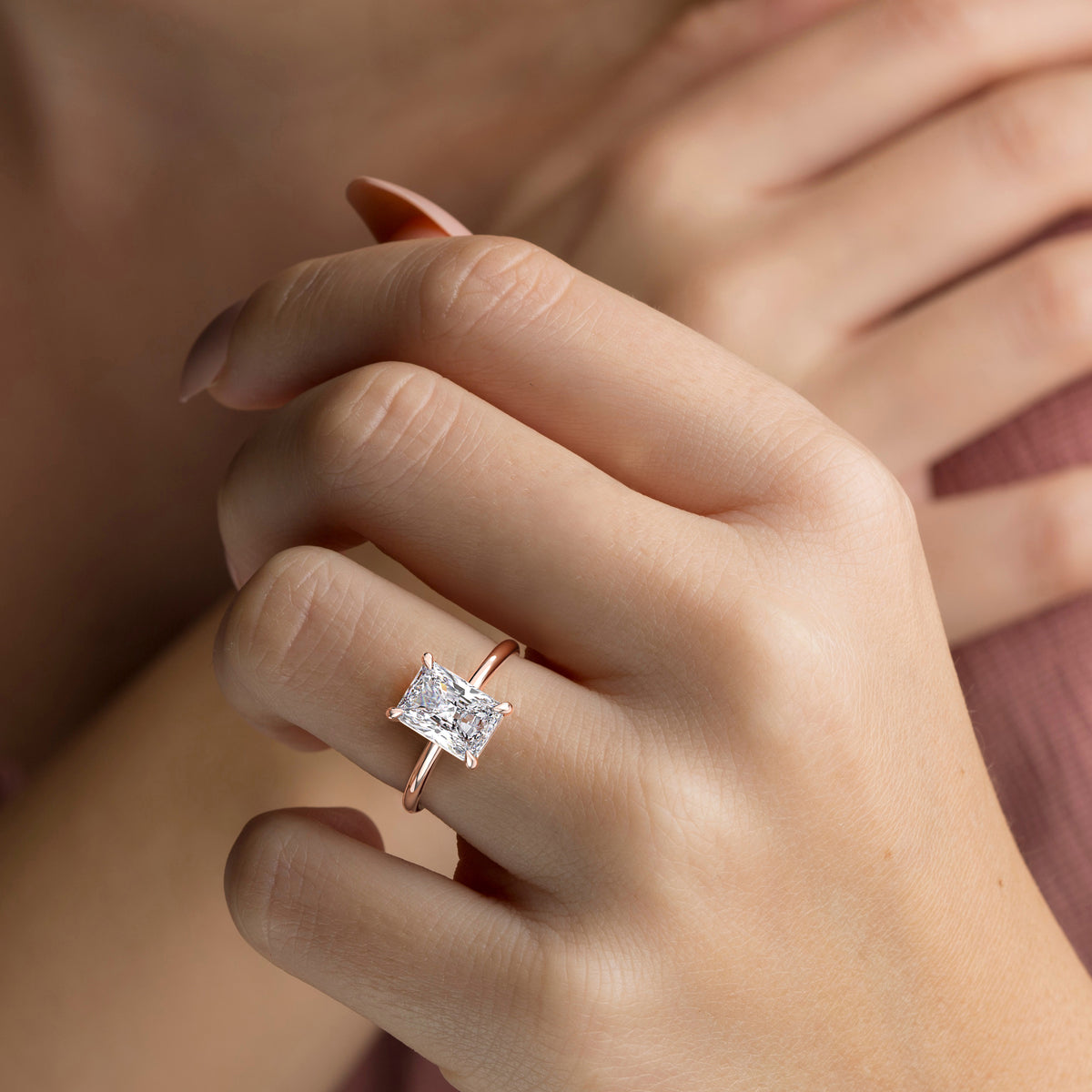 Elegant 14K/18K rose gold solitaire engagement ring featuring a radiant diamond shape, showcased on a model's hand.
