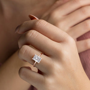 Elegant 14K/18K rose gold solitaire engagement ring featuring a radiant diamond shape, showcased on a model's hand.