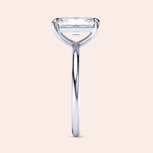 Elegant 14K and 18K white gold solitaire engagement ring with emerald-cut diamond, showcasing a sleek design.