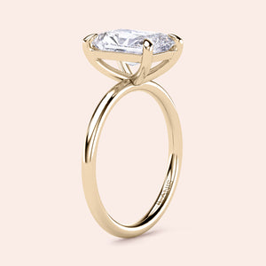 Elegant yellow gold engagement ring featuring an elongated radiant-cut diamond, available in 14K, 18K, or platinum settings.