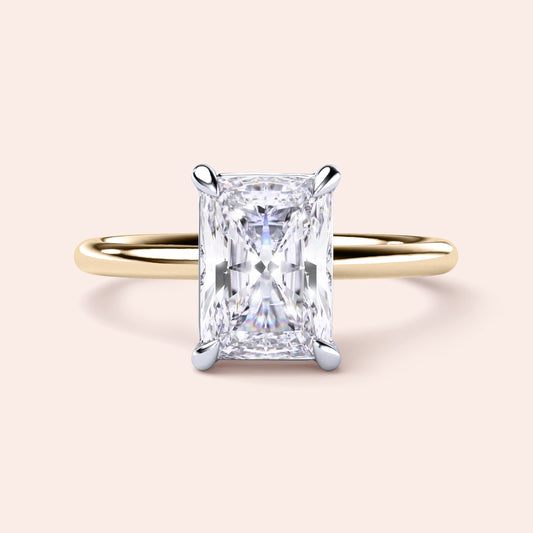 Two-tone 14K/18K white and yellow gold diamond ring featuring a radiant-cut center stone in a classic solitaire design. 