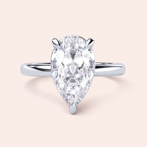 Pear-shaped diamond engagement ring in a sleek 14K or 18K white gold band, showcasing timeless elegance and brilliance. 