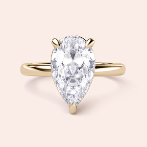 Elegant pear-shaped diamond engagement ring in 14K gold, highlighted on a neutral background for a stunning display. 