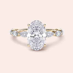 Elegant yellow gold engagement ring featuring an oval diamond and marquise side stones, available in 14K and 18K gold or platinum.