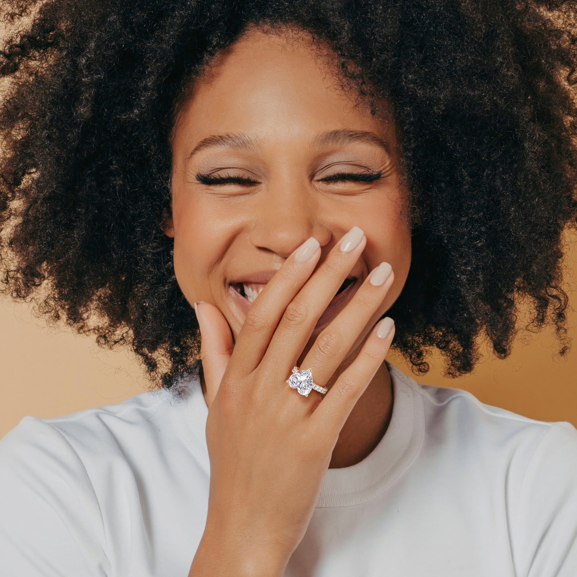 Close-up of a smiling model showcasing the L-387 WILLOW heart hidden halo diamond accents engagement ring in 14K gold or 18K gold.|




#14KRecycledYellowGold
#18KRecycledYellowGold





