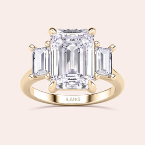 Radiant-cut diamond engagement ring with side stone accents in 14K yellow gold, displayed on a neutral background.