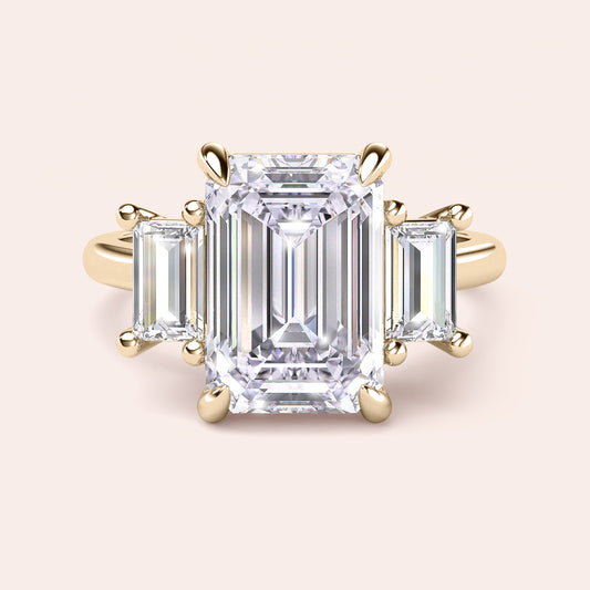 Radiant-cut diamond engagement ring with side stone accents in 14K yellow gold, displayed on a neutral background.