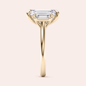Radiant-cut diamond engagement ring with side stone accents in 14K yellow gold, displayed on a neutral background.