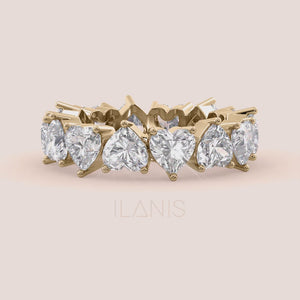 Close-up video of heart diamond eternity ring in yellow gold, capturing light reflection, prong details and full eternity sparkle in motion 