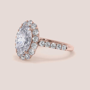 14K and 18K gold oval-shaped diamond halo engagement ring with round diamonds framing the center gem, exuding elegance.
